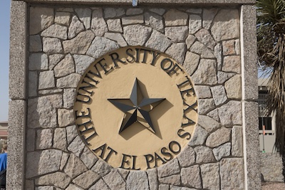 Outside, stone sign with a circle in the center reading The University of Texas at El Paso. Those words encircle a star.