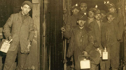 Photo, At the close of the day. Waiting for the cage to go up. The cage is entirely open on two sides and not very well protected on other two, and is usually crowded like this. Small boy in front is Jo Pume, a Nipper, 163 Pine Street. Shaft #6, Pennsylvania Coal Co.,. Location: South Pittston, Pennsylvania., January 11, 1911, Library of Congress Photo, At the close of the day, January 1911, Lewis Hine, Library of Congress