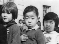 Photo, San Francisco, Calif., April 1942. First-graders, some of Japanese ancestry, at the Weill public school pledging allegience to the United States flag. The evacuees of Japanese ancestry will be housed in War relocation authority centers for the duration of the war, Attributed to Dorothea Lange, Library of Congress Photo, San Francisco, Calif., April 1942. . . , Library of Congress