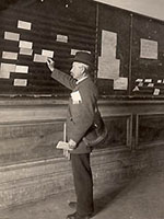Photo, The Angel of Death, as he was known, leaving cinch notices (reports of bad mid-term grades) on the students mail board in North Hall, c. 1900 Photo, The Angel of Death leaving cinch notices on the students mail..., c. 1900